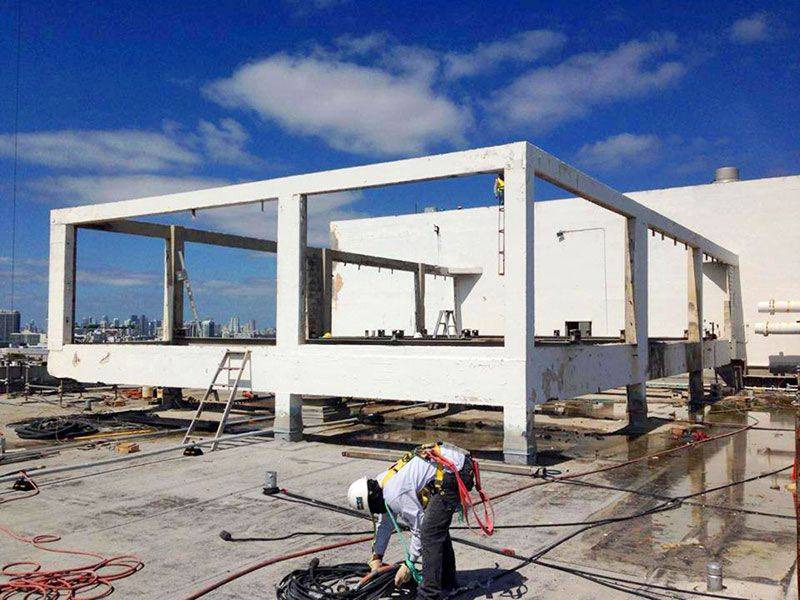 Two men working on the construction of a building in a gallery.