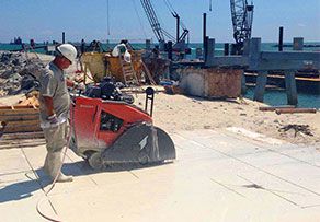 A man is working on a concrete slab at a construction site.