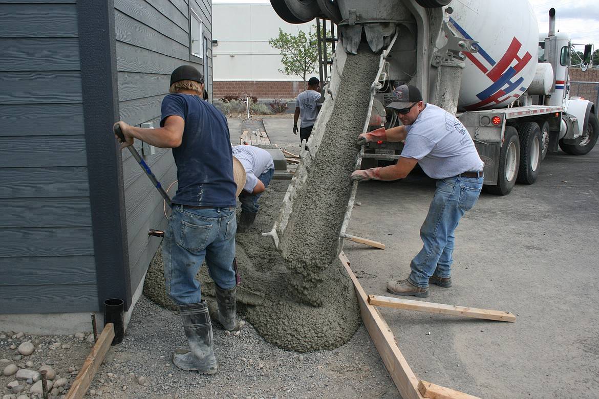 A group of men are Breaking & Removing concrete in front of a house.