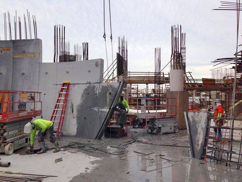 Construction workers are performing concrete cutting at a construction site.